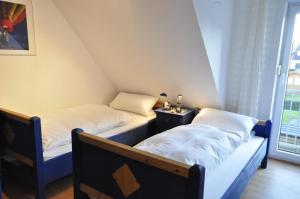 2 łóżka pojedyncze w pokoju z oknem w obiekcie Ferienhaus Wattje Am Yachthafen 102 E w mieście Harlesiel