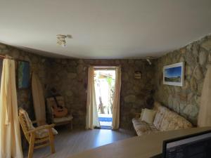 a living room with a couch and a guitar at Pousada Aurora in Praia do Rosa