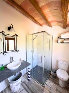 uma casa de banho com uma cabina de duche em vidro e um lavatório. em Mas Segart em Santa María de Palautordera