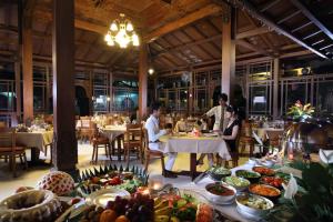 un grupo de personas sentadas en mesas en un restaurante en Cakra Kembang Hotel, en Yogyakarta