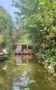 ein Haus auf einer Brücke über einen Fluss in der Unterkunft Casa aan de Plas, B&B met sauna en hottub of jacuzzi in Nieuwkoop