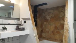 a bathroom with a shower with a stone wall at Hotel Wippertal in Bernburg