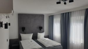 1 dormitorio con 2 camas y ventana en Hotel Wippertal, en Bernburg