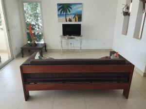 un grande letto in legno in una camera con TV di Apartamentos no Pipa Residence a Pipa