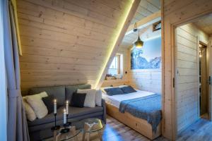 Un dormitorio con una cama y un sofá en una habitación. en Domek Góralski - Górski HYR, en Zakopane