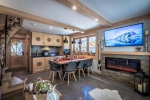 a kitchen and dining room with a fireplace and a tv at Domek Góralski - Górski HYR in Zakopane