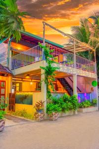a house with a staircase on the side of it at Green Leaf Guest House - Omadhoo in Omadhoo