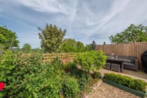 um jardim com um banco e uma cerca em Immaculate luxury retreat in pretty village with great pubs - Box Valley Cottage em Stoke by Nayland