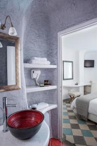 La salle de bains est pourvue d'un lavabo rouge. dans l'établissement Ikastikies Suites, à Firostefani