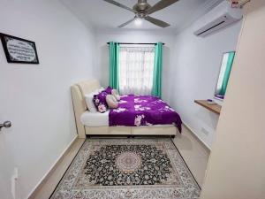 een slaapkamer met een bed met paarse lakens en een raam bij Homestay Ampang Farah in Ampang +11 foto's