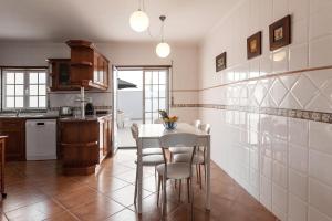 uma cozinha com mesa e cadeiras num quarto em Ocean Breeze Villa em Atouguia da Baleia