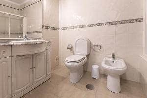 Un baño blanco con inodoro y lavabo. en Ocean Breeze Villa, en Atouguia da Baleia 17 fotos más
