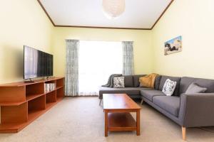 a living room with a couch and a tv at Kangaroo Pause -Home with yard & parking -Free wine in Hope Valley
