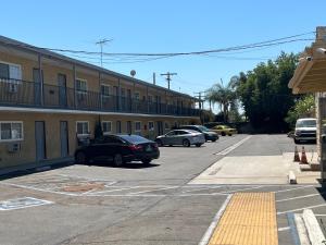 a parking lot with cars parked in front of a building at Keystone Motel in Norwalk