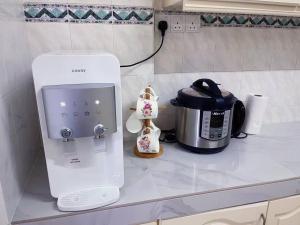 une cafetière assise sur un comptoir à côté d'un grille-pain dans l'établissement Homestay Ampang Farah, à Ampang