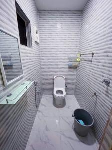 a bathroom with a toilet and a bucket in it at Homestay Ampang Farah in Ampang