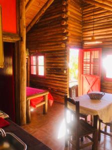 a dining room of a log cabin with a table at Cabañas del Mesón in Potrerillos