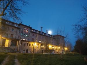 Un grand bâtiment en pierre avec des lumières allumées la nuit dans l'établissement Balneario de Corconte, à Cabanas de Virtus