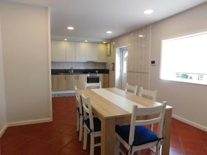 eine Küche mit einem Holztisch und Stühlen in der Unterkunft Casa da Veiga in Lago