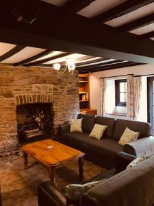 a living room with a couch and a fireplace at Cobblers Cottage in Brecon Beacons in Brecon