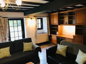 a living room with two couches and a kitchen at Cobblers Cottage in Brecon Beacons in Brecon