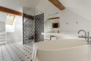 y baño blanco con bañera y ducha. en Hotel At the White Lily, en Praga