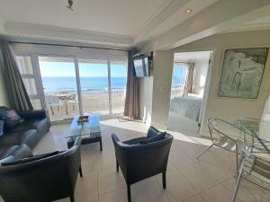 a living room with a view of the ocean at 3 Bedroom Sea Facing Family Apartment Cape Town Moullie Point in Cape Town