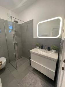 a bathroom with a sink and a shower with a mirror at Apartment Solare in Portorož +37 photos