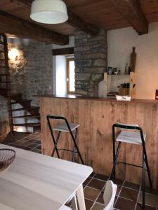 聖萊伊德蘇的住宿－Maison de village au cœur des remparts，一间带桌子和两张凳子的用餐室
