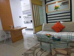 uma sala de estar com um sofá e uma mesa de vidro em Shaftsbury Residence Cyberjaya Wifi, Netflix, Free Parking em Cyberjaya