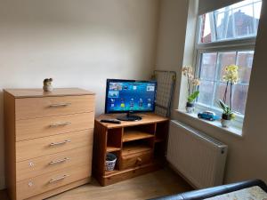 a bedroom with a desk with a computer and a dresser at Stefi apartment room in Edgware