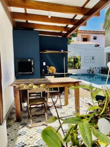 eine Terrasse mit einem Holztisch und einem Kamin in der Unterkunft Residencial Vila das Canoas in Bombinhas
