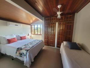 a bedroom with two beds and a ceiling fan at Residencial Maria Pitanga in Arraial d'Ajuda +194 photos