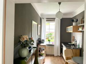a kitchen with a vase of flowers on a counter at JETHON Appartement in der Gasse in Nienburg +10 photos