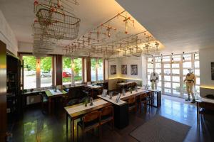 a restaurant with tables and chairs in a room with windows at Otto's Parkhotel Saarlouis in Saarlouis