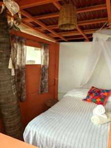 a bed in a room with a tree at Casa Corazón San Agustinillo in San Agustinillo