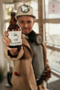 a man dressed as a person holding a bottle of beer at Otto's Parkhotel Saarlouis in Saarlouis