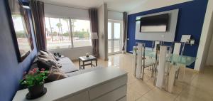 un soggiorno con divano e TV di La Rosa de los vientos luxury apartment ad Adeje