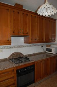 a kitchen with wooden cabinets and a stove top oven at Casa Rural Consuelo in Jumilla