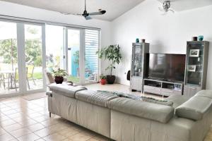 ein Wohnzimmer mit einem großen Sofa und einem Flachbild-TV in der Unterkunft Relaxing Property with Stunning Views and Pool in Toa Baja