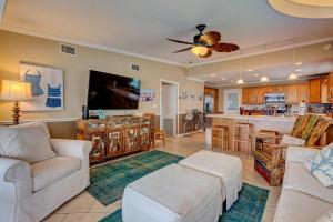 a living room with white furniture and a kitchen at Bathing Suit Beach Bungalow in Ormond Beach