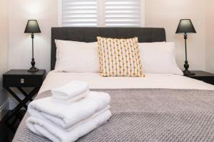 een slaapkamer met een bed met witte handdoeken bij Character filled cottage in Norwood - Free wine in Adelaide