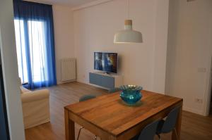 ein Wohnzimmer mit einem Tisch und einem TV in der Unterkunft La Cicada in Camerano