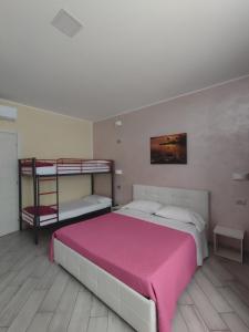 カルダーノ・アル・カンポにあるVilla Ormeniのベッドルーム1室(二段ベッド2台、ピンクのベッドカバー付)