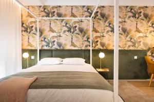 1 dormitorio con 1 cama y papel pintado con motivos florales en Savannah Apartment, by Bolhão Residences en Oporto