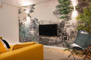 a living room with a tv and a yellow couch at Savannah Apartment, by Bolhão Residences in Porto