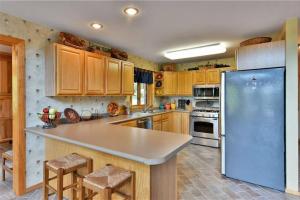 une cuisine avec des armoires en bois et un réfrigérateur bleu dans l'établissement Sandy Lake Cabin ~Private Luxury Vacation Home~, à Minong