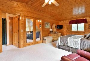 une chambre avec un lit et une salle de bain dans une cabine dans l'établissement Sandy Lake Cabin ~Private Luxury Vacation Home~, à Minong