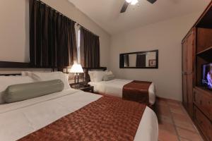a hotel room with two beds and a flat screen tv at The Bungalows on Shary in McAllen