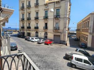 un estacionamiento con autos estacionados frente a un edificio en Casa vacanze Al Porto, en Catania